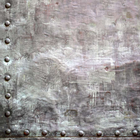 Black grunge metal plate or armour texture with rivets as backgroundの写真素材