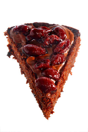 Piece of chocolate cake with icing and cherry on white background