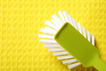 Yellow sponge background and cleaning brushの写真素材