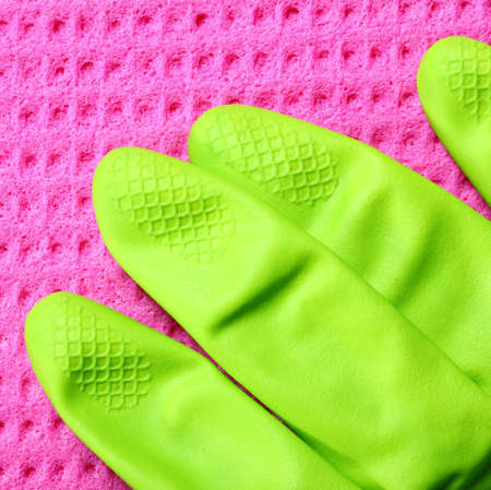 Close up pink kitchen sponge and green rubber gloveの写真素材