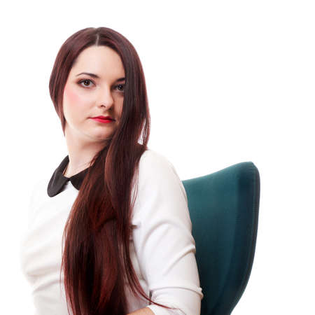 Portrait of a beautiful brunette young business woman sitting on chair white backgroundの写真素材