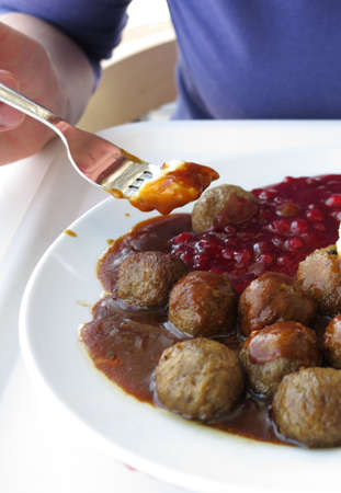 Food being eaten. Swedish meatballs potatoes cranberry on dish. A traditional scandinavian culinary.の写真素材
