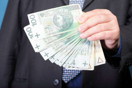 Businessman's hand holding polish money banknote