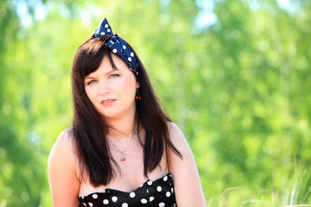 Picnic outdoors. Portrait of young woman against background of summer nature.  Retro style.の写真素材