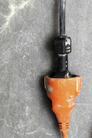 closeup cable electrical plug in the electric extension cord on floor workplaceの写真素材