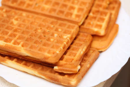 Stack of sweet belgian waffles on white plateの写真素材