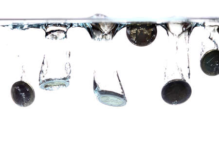 Euro coins falling into the clear water on white backgroundの写真素材