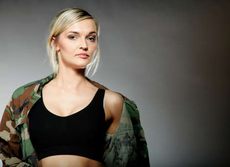woman in military clothes army girl on gray background.
