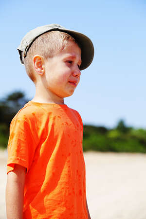 Sad child. Portrait of crying unhappy little boy outdoorの写真素材