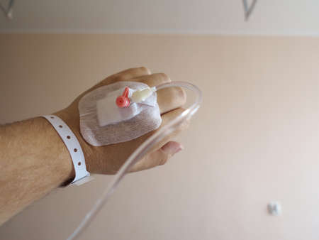 Arm of a male patient in the hospital with an iv intravenous dripの写真素材