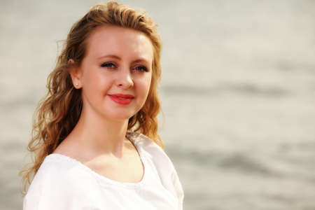 Portrait young woman smiling blonde girl on beach wind in hair , summer holidayの写真素材