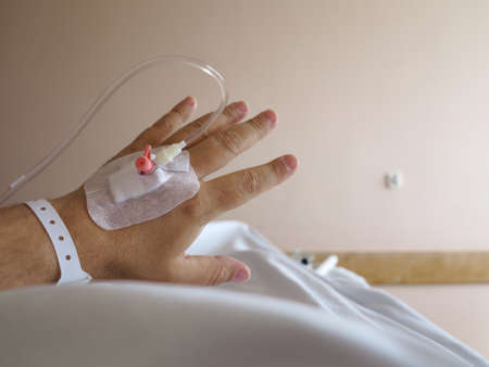 Arm of a male patient in the hospital with an iv intravenous dripの写真素材