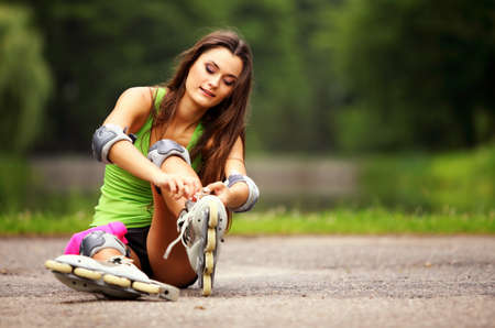 Happy young girl enjoying roller skating rollerblading on inline skates sport in park. Woman in...
