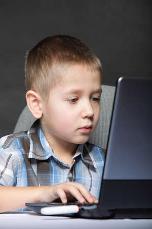Computer addiction child boy with laptop notebook black background