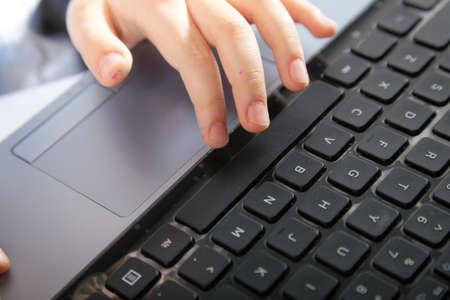 Cropped image of boy's schoolboy's hand typing on laptop keyboardの写真素材