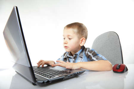 Computer addiction child boy with laptop notebook white backgroundの写真素材