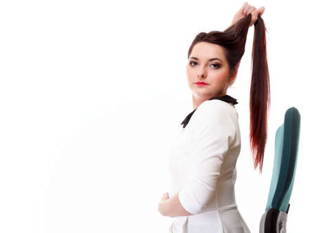 Portrait of a beautiful brunette young business woman sitting on chair white backgroundの写真素材
