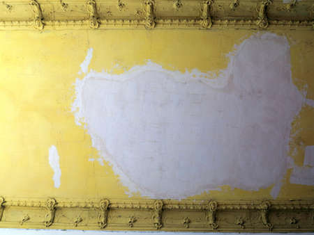 Damaged yellow ceiling in an old abandoned home as backgroundの写真素材