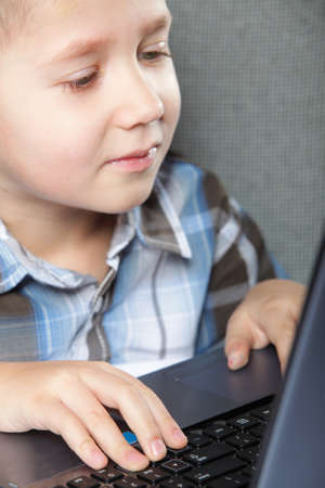 Computer addiction child boy with laptop notebook black backgroundの写真素材