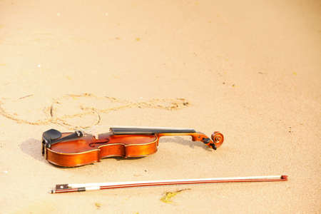 Violin string and g treble clef shape on sandy beach. Love of music conceptの写真素材
