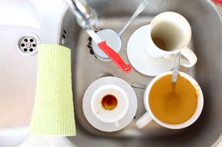 Washing up. White dirty dishes in the kitchen sink.の写真素材