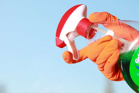 hand in orange glove cleaning window with spray detergent. Spring cleaning conceptの写真素材