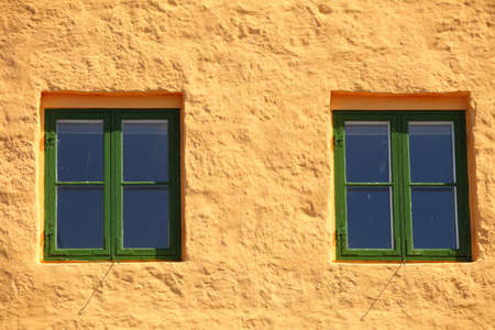 green two windows on orange wall background house fasade architecture detail, scandinaviaの写真素材