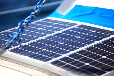 Solar charging batteries aboard a sail boat. Photovoltaic panels renewable eco energy concept