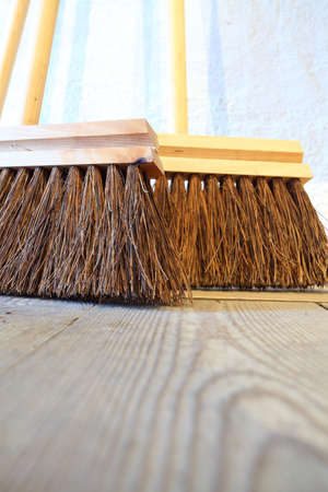 Close up large brooms for house work on old wooden floor of country house. Sweepingの写真素材