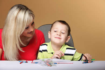 mother and son drawing together, mom helping with homework daycare brown background