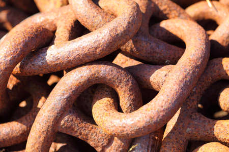 Closeup of large rusty old used chain links as background textureの写真素材