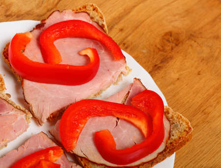 Healthy open faced sandwich with red paprika ham on wooden table backgroundの写真素材