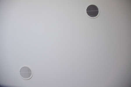 circular plastic air vent in white wall ventilation grill