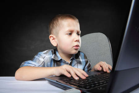 Computer addiction child boy with laptop notebook black background