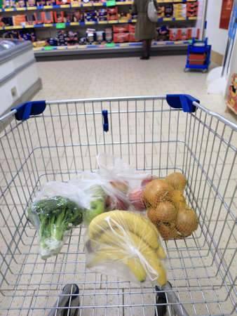 view of a shopping cart with grocery items at supermarketの写真素材