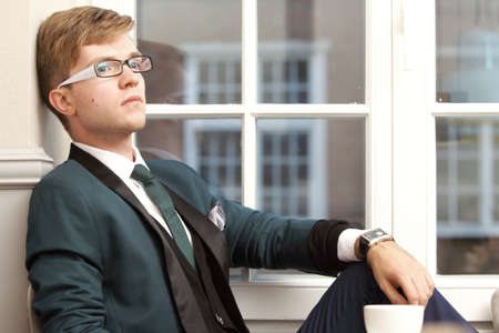 Young handsome stylish man fashion model relaxing thinking and waiting in cafe /restaurant with...