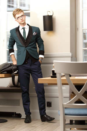 Full length young handsome stylish man fashion model posing in trendy cafe /restaurant with bagの写真素材