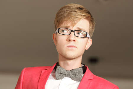 Portrait young handsome stylish man fashion model in glasses wearning bright red jacket and bow tie...