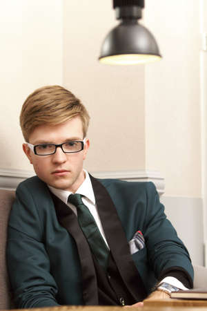 Young handsome stylish man fashion model relaxing thinking and waiting in cafe /restaurantの写真素材