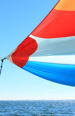 The wind has filled the spinnaker on sailing yacht. Detail of a colorful sail against the deep blue sky.の写真素材