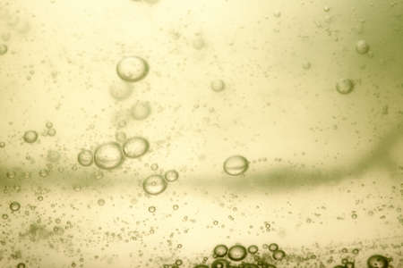 Green yellow abstract blurred liquid background with soap bubbles