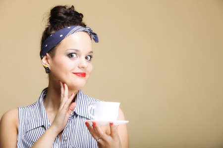 Hot beverage. Woman funny girl holding a cup of tea or coffee copyspace brown backgroundの写真素材