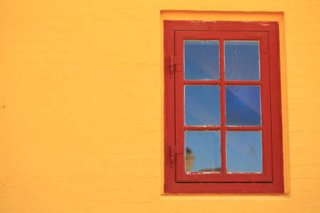 red window on orange wall background house fasade architecture detail, scandinavia