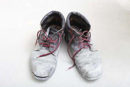pair of old dirty work boots in construction siteの写真素材