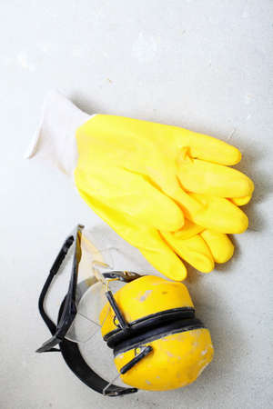 Renovation at home. Construction equipment tools work gloves yellow protective noise muffs in building site.の写真素材