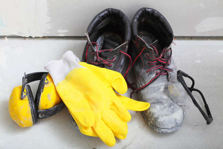 Renovation at home. Construction equipment tools work boots yellow protective noise muffs gloves...