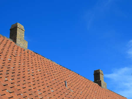 The old roofing tiles red clay house roof with chimney sky の写真素材