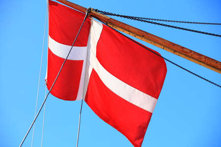 The denmark or danish flag on sailboat with blue sky の写真素材