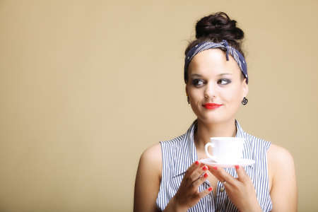 Hot beverage. Woman funny girl holding a cup of tea or coffee copyspace brown backgroundの写真素材