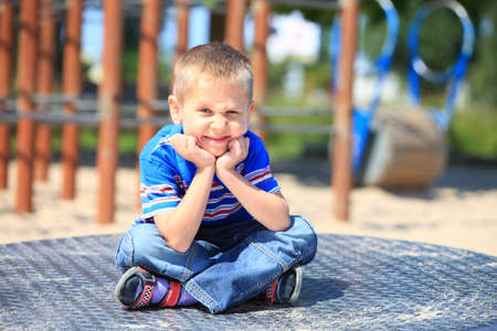 thoughtful child boy or kid in playground on leisure equipmentの写真素材